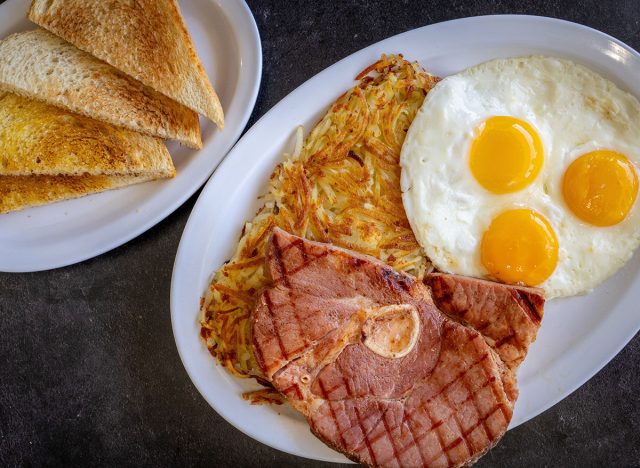 ham steak and eggs on a black background
