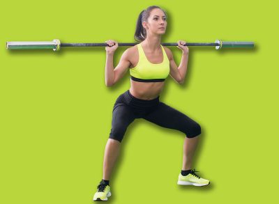 young fit woman doing squats with barbell, exercising back and legs muscles
