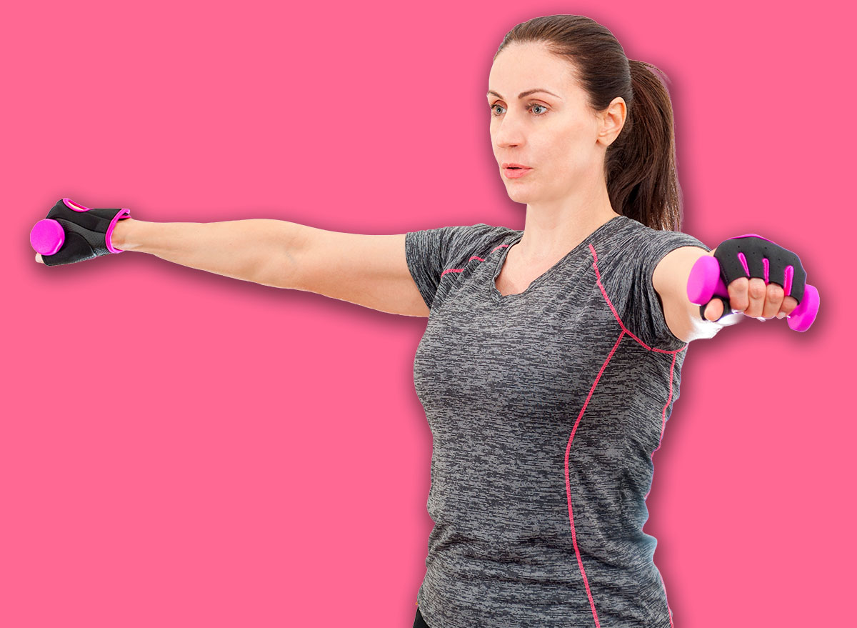 Working out and staying in good health at any age concept with happy mature woman exercising her shoulders by doing lateral shoulder raise exercise isolated on white background with a clipping path