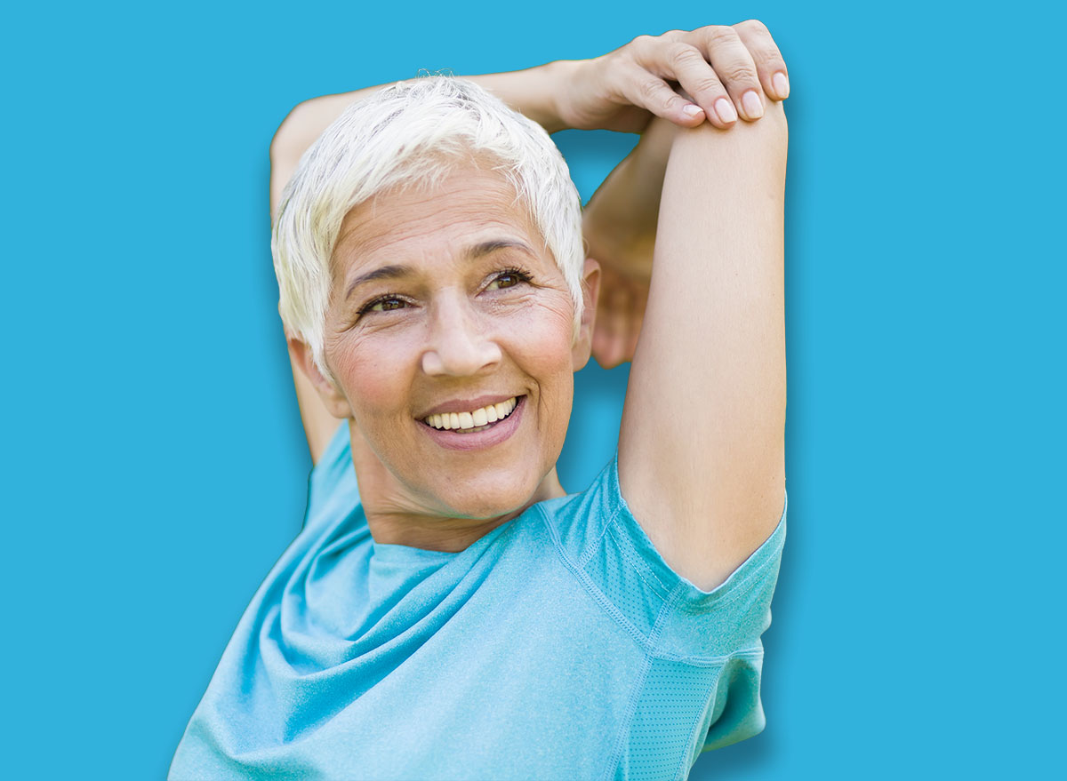Portrait of senior woman doing exercise for stretching arms in the park