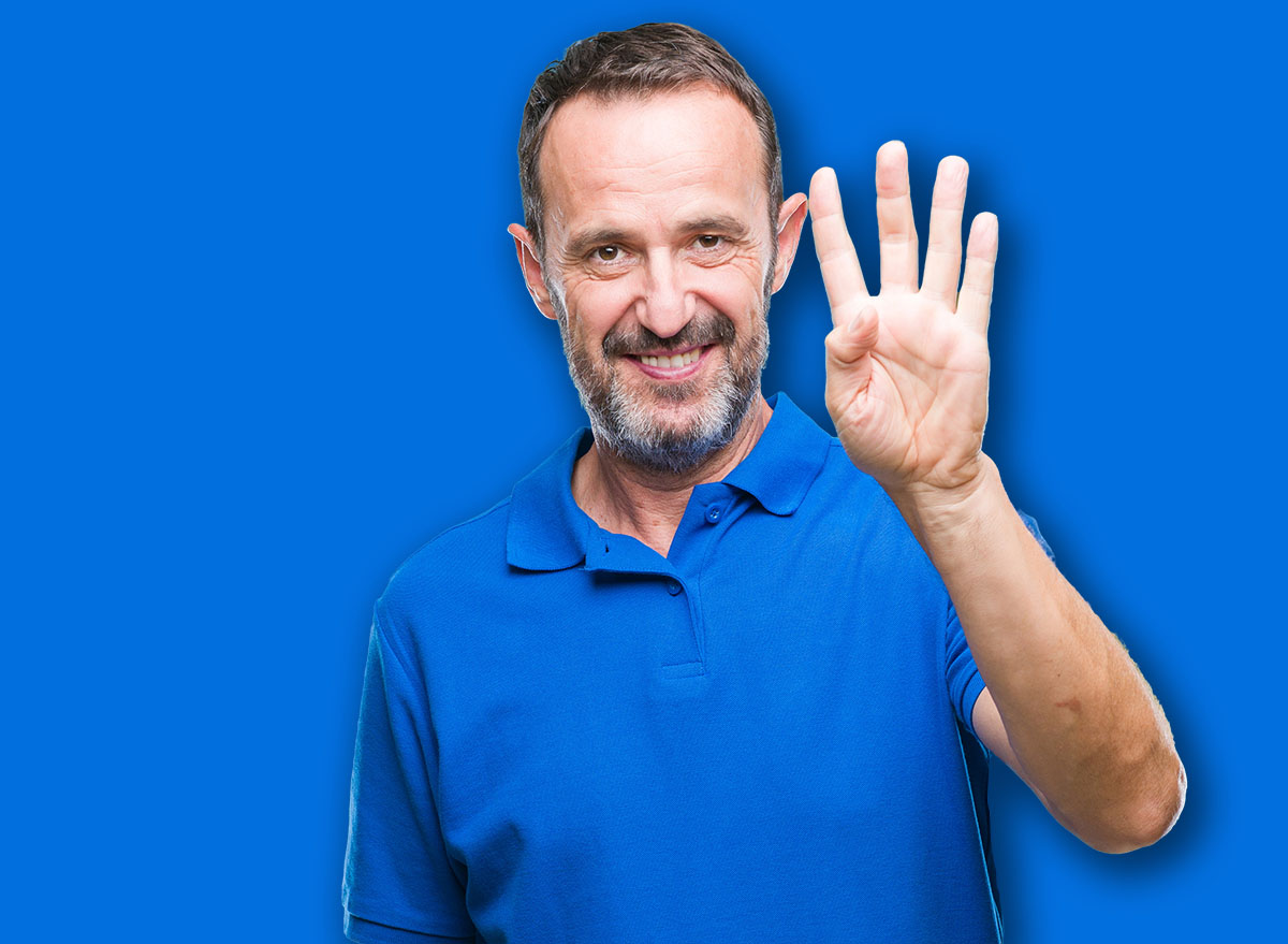 Middle age hoary senior man over isolated background showing and pointing up with fingers number four while smiling confident and happy.
