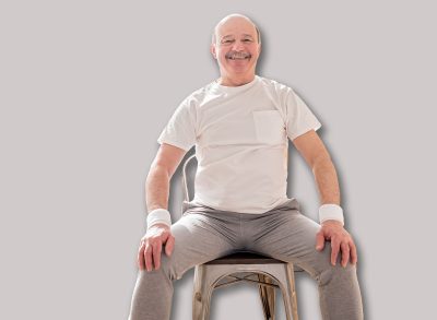 Elderly man wearing sport clothing sitting on chair ready for online yoga lesson