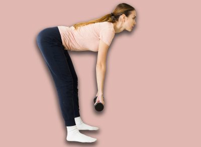 Attractive sporty girl doing leg and glute workout in gym, performing romanian deadlift with dumbbells. Concept of weight training for women