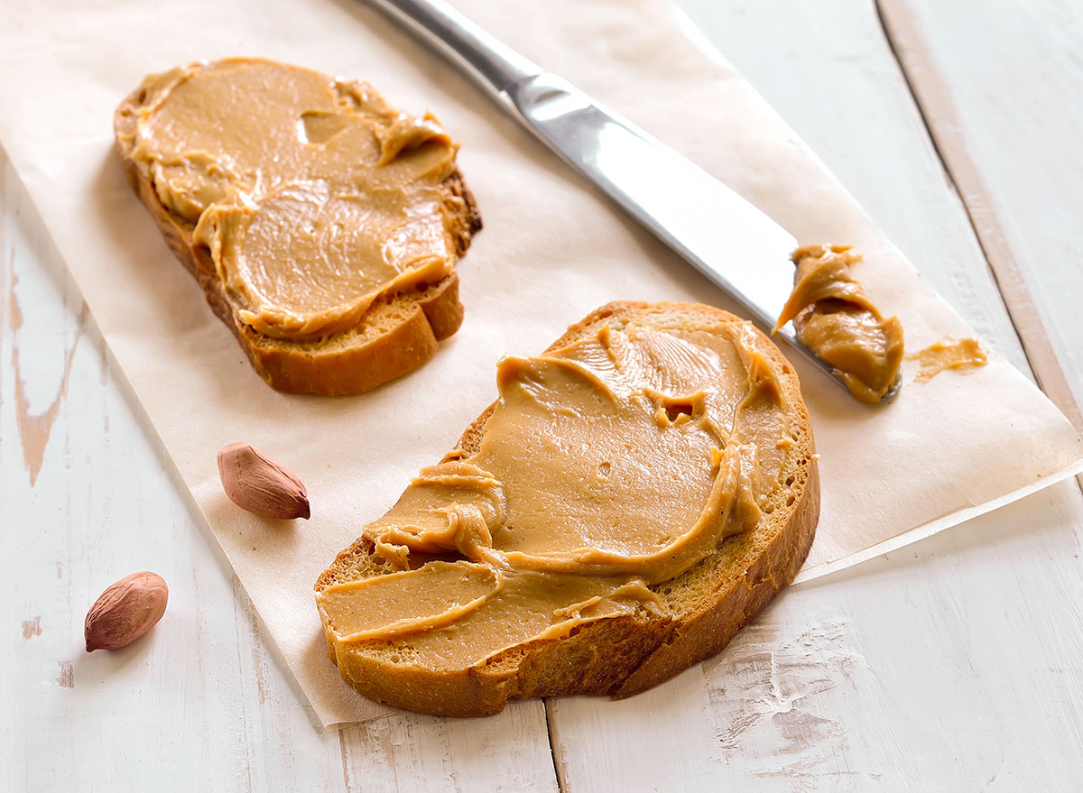 Peanut butter sandwiches or toasts on light wooden background