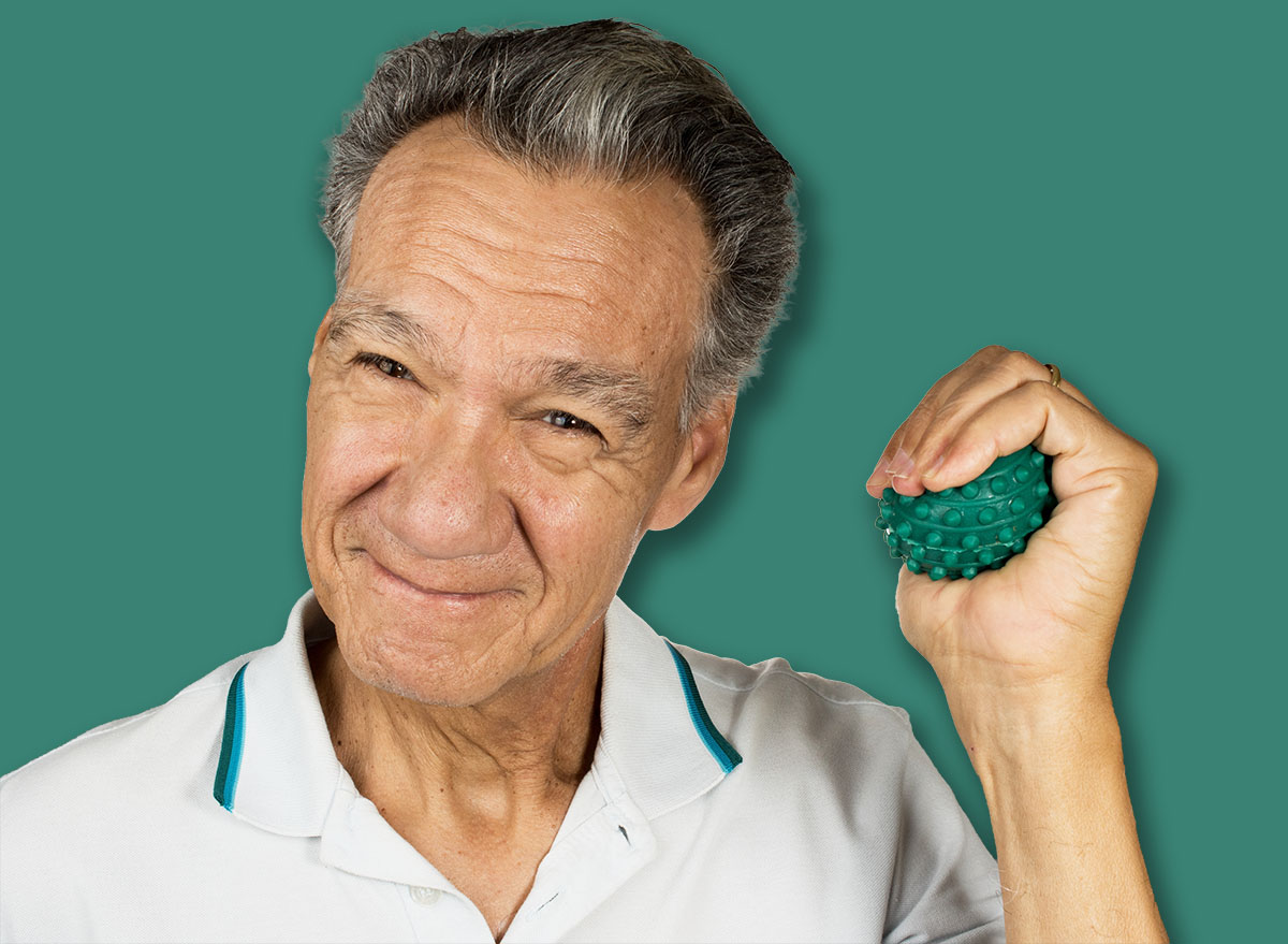 Mature man holding and squeezing massage therapy spike balls