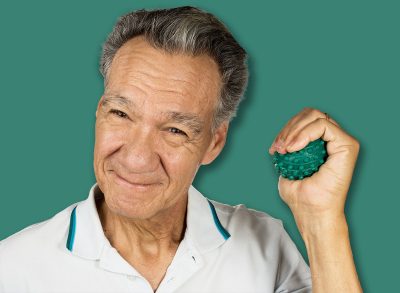 Mature man holding and squeezing massage therapy spike balls