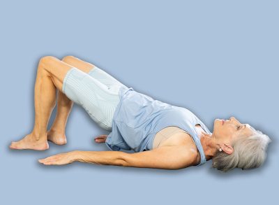 Three generations of women perform half bridge Setu Bandha Sarvangasana, glute bridge in gym. Multi generational family doing yoga together