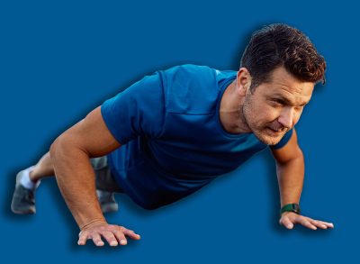 Male athlete exercising push-ups during strength training in outdoor gym. Copy space.