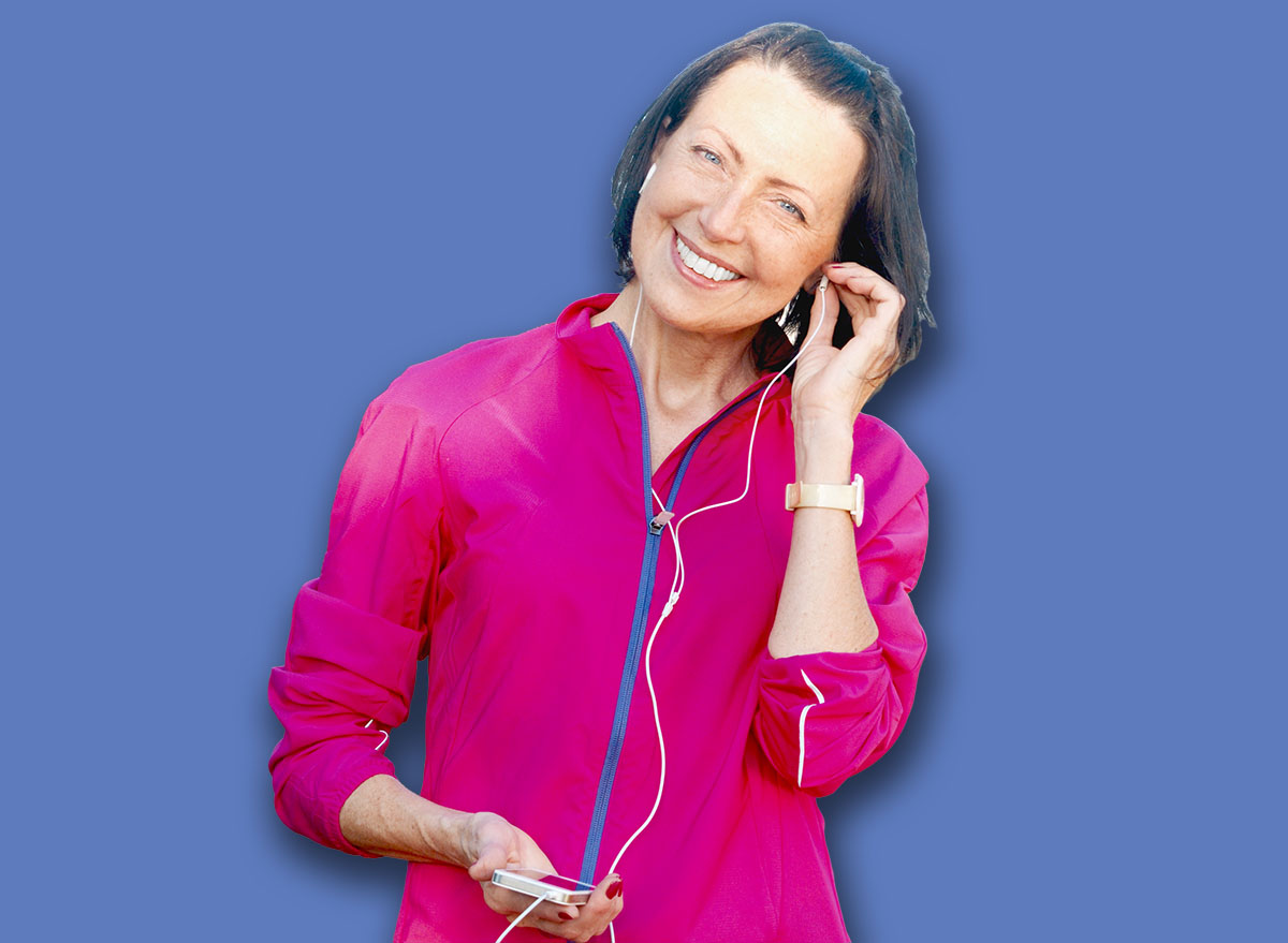 Mature woman listen music before or after jog in the park. Attractive looking mature woman keeping fit and healthy