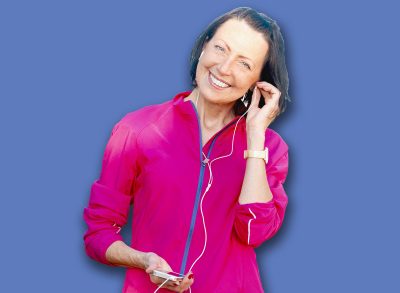 Mature woman listen music before or after jog in the park. Attractive looking mature woman keeping fit and healthy