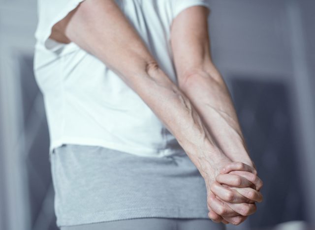 Clasped Hands Behind Woman s Back. Stretching By Clasping Hands Behind Back. Selective Shot. Woman Stretching Her Arms Behind