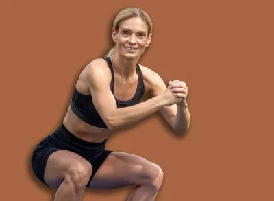 Beautiful woman working out doing squats in summer park.