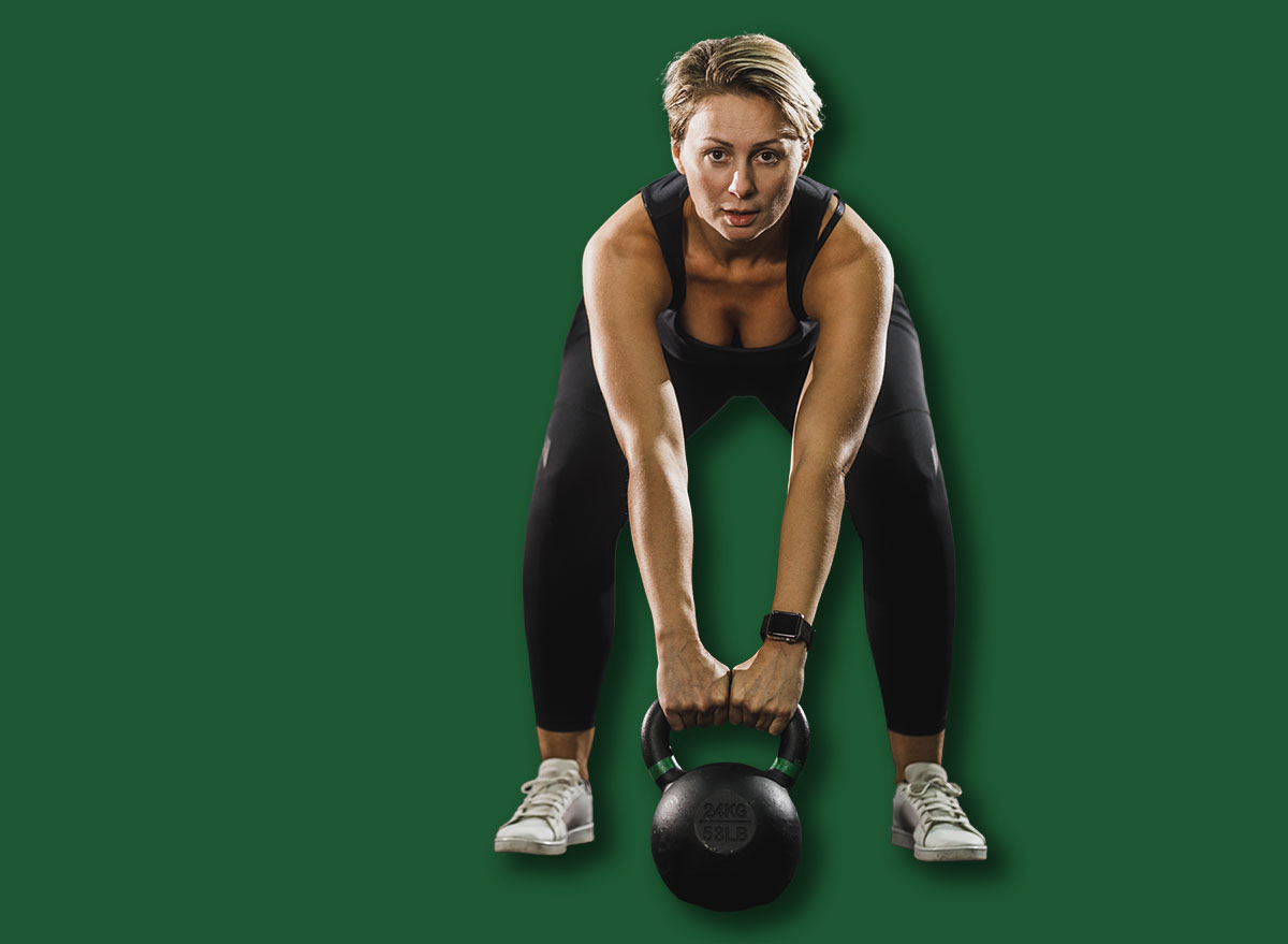 Female athlete working out with kettlebell at the gym.
