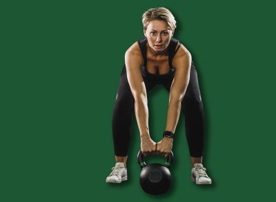 Female athlete working out with kettlebell at the gym.