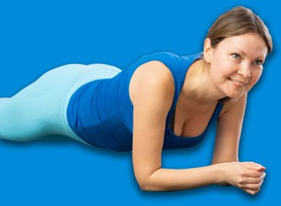 Diligent women practicing plank pose of yoga on black mat in light fitness room with house plants