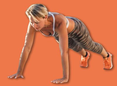 Fit middle age woman doing push-up exercises during hard training near the sea beach.