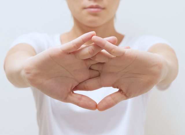 Asian women stretch arms in front of the body to warm up before exercising and do it for the muscles to relax.