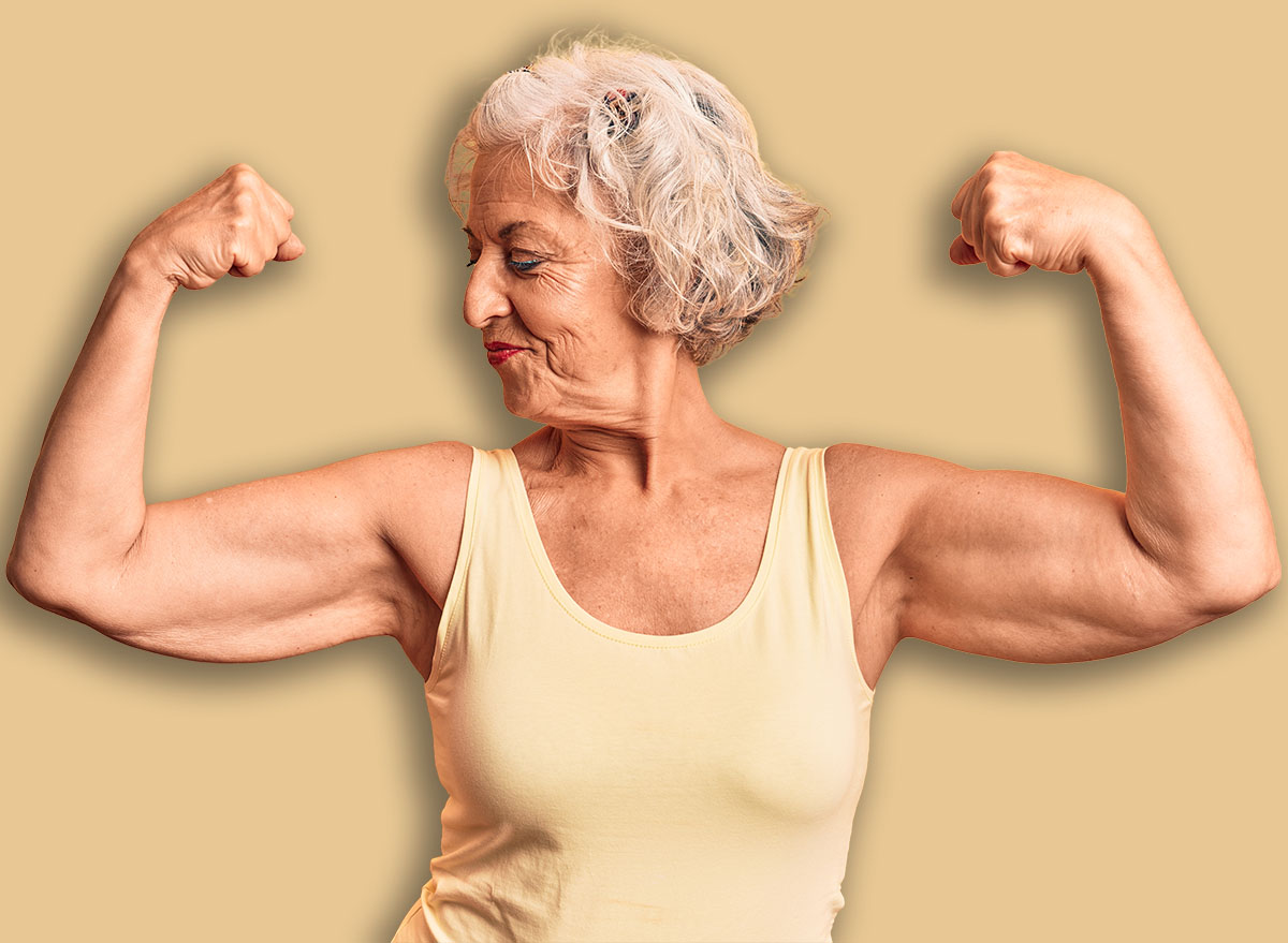 Senior grey-haired woman wearing casual clothes showing arms muscles smiling proud. fitness concept.