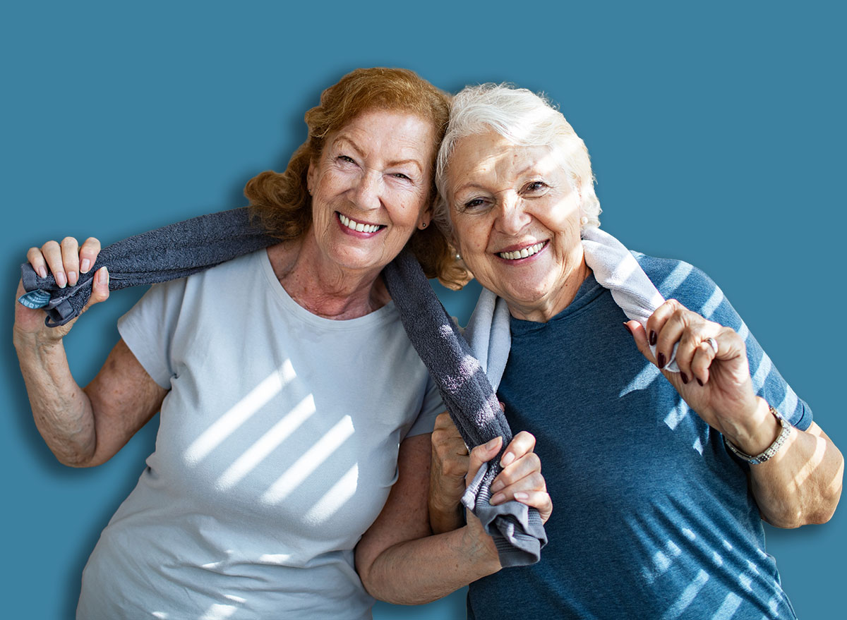 Active senior lesbian couple smiling after workout with towels around necks