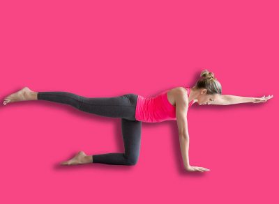 Slim Caucasian woman practice bird dog drill exercise standing on all fours with one leg and arm up in loft fitness studio.