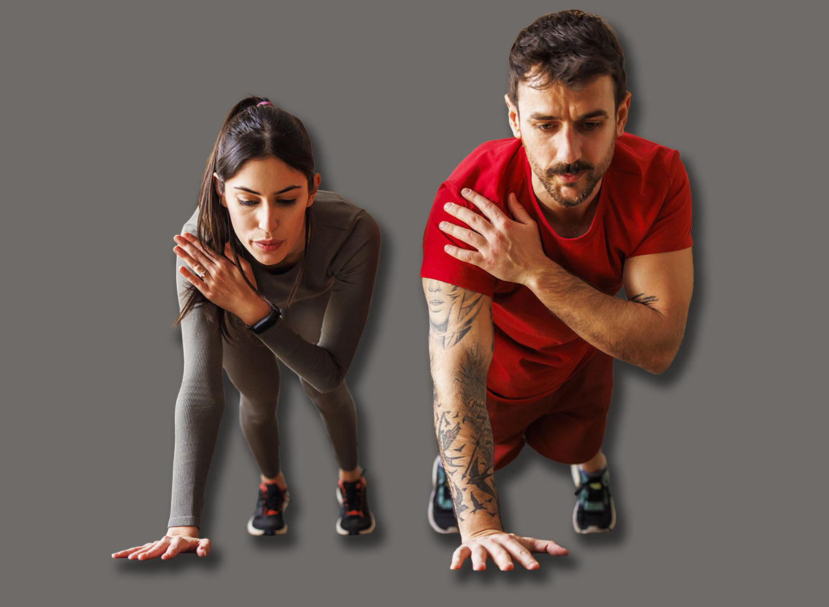 Active fit couple in sportswear doing plank shoulder taps exercise while working out together at home