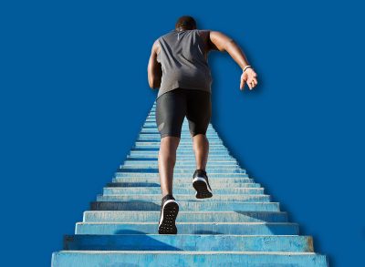 Back view of a young man running upstairs at a stadium