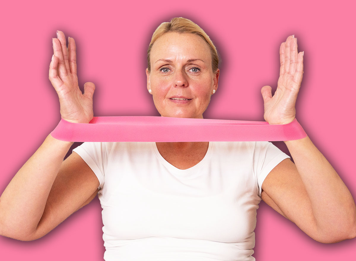 Active mature woman training arms with elastic band at home, promoting healthy lifestyle, rehabilitation, and senior fitness.