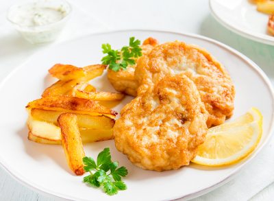 Homemade fish cakes with french fries on white plate close up