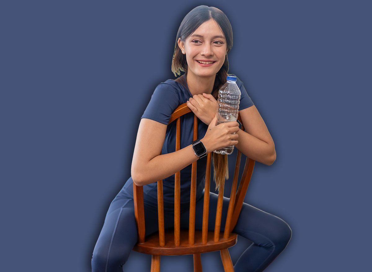 Happy sporty woman sitting on chair holding water bottle after home workout, beautiful young female in sportswear resting, fitness, healthy lifestyle, hydration and weight loss concept