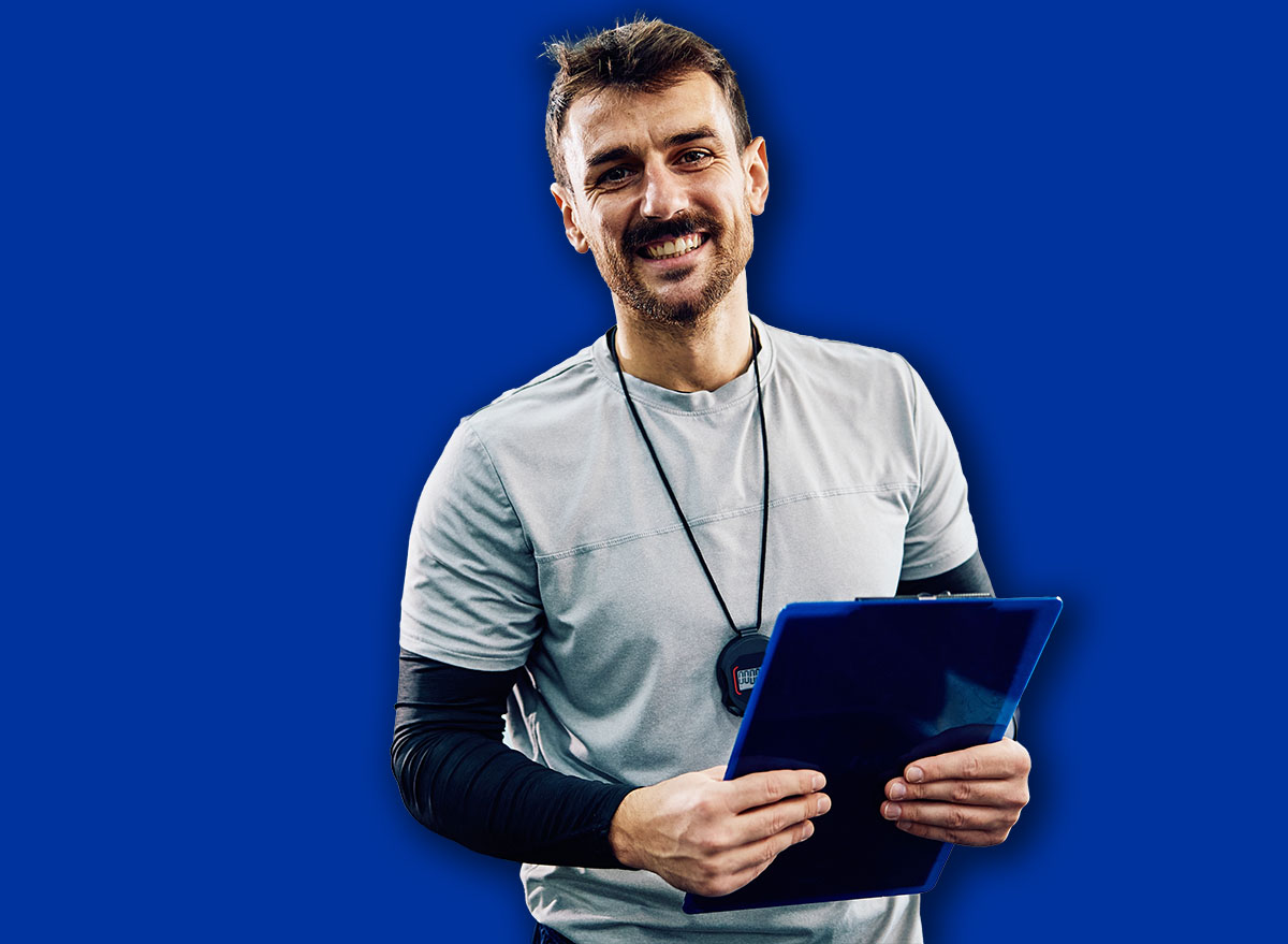 Happy personal trainer working in health club and looking at camera. Copy space.