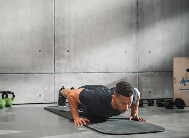 Online Workout Service: Professional Trainer Exercises, Video Tutorial, Virtual Training. Handsome Black Athletic Coach Teaching, Showing How to Do Push ups. Wide Angle Shot