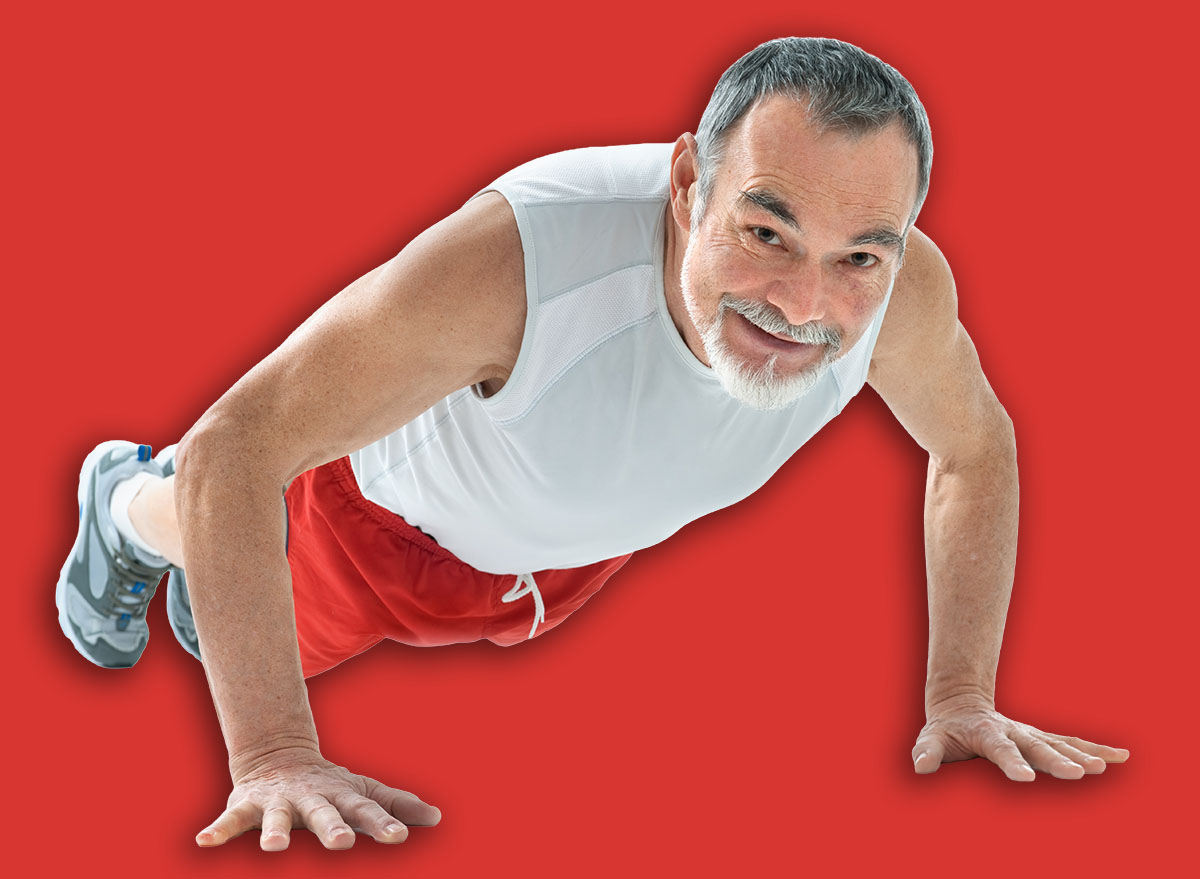 senior man doing push-ups exercise in gym.