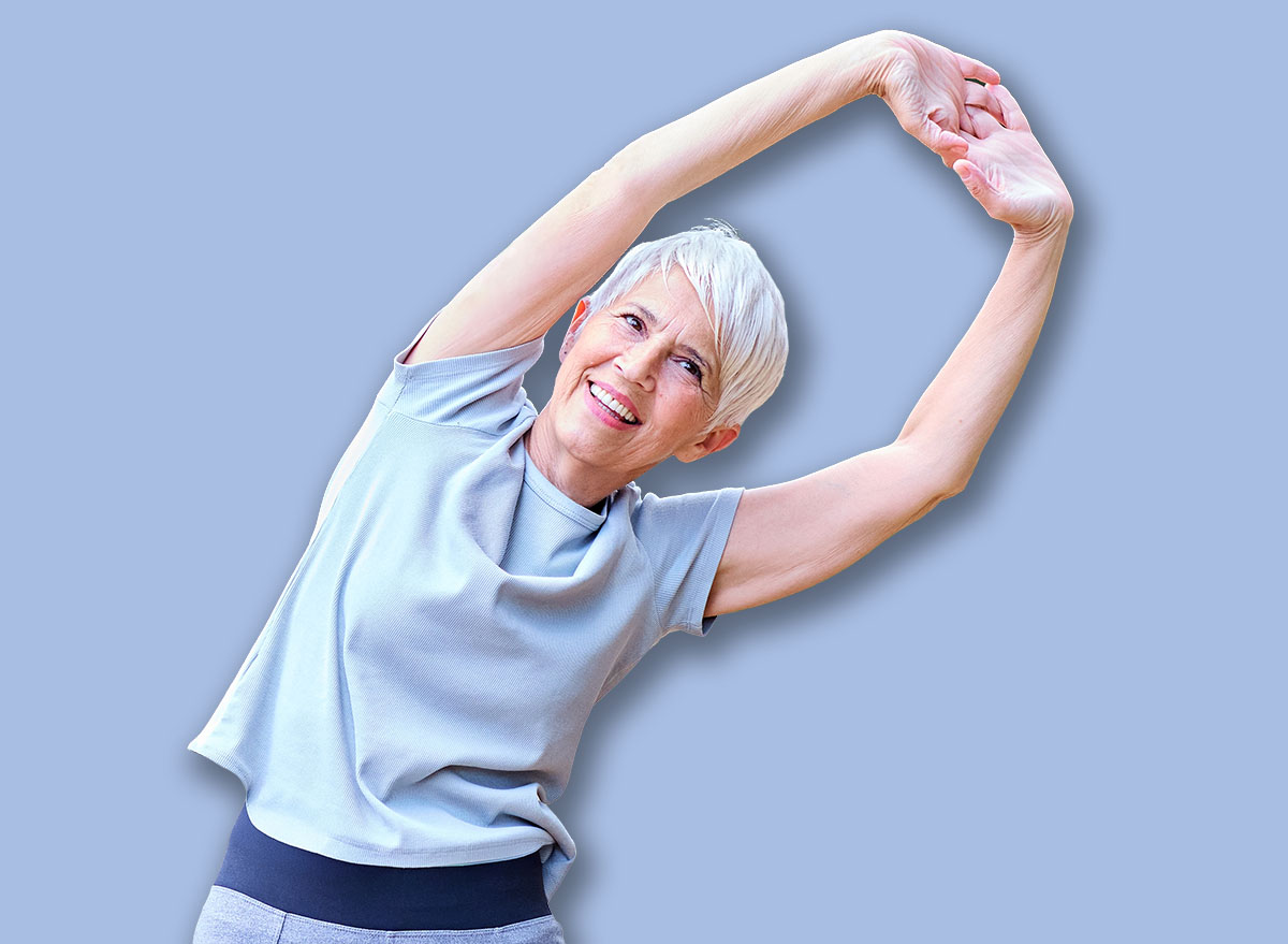 Portrait os a happy beautiful elderly senior mature woman exercising and stretching outdoors