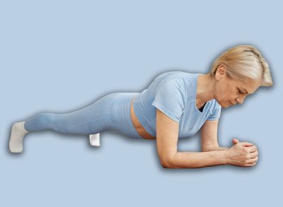 Caucasian woman performing plank exercise on yoga mat in living room, maintaining focused expression while engaging core muscles during home workout routine