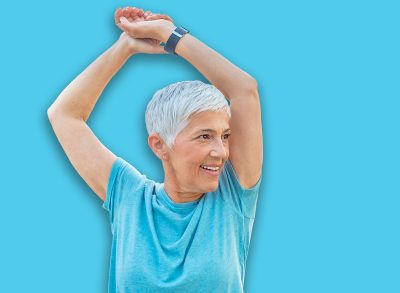 Fitness and stretching exercises outdoor. Beautiful sportswoman exercising on autumn park. Caucasian senior sporty woman doing pilates. Copyspace.