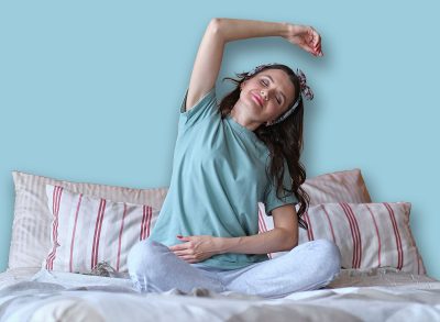 middle aged Woman doing yoga exercise on bed at home. Morning workout in bedroom. Healthy and sport lifestyle.
