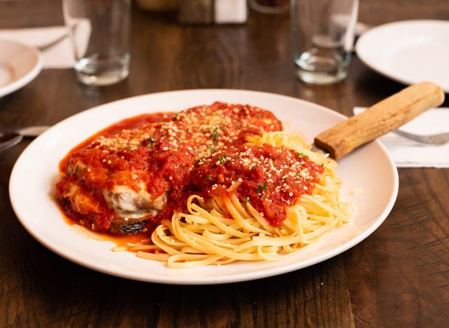 Italian Eggplant Parmesan with Side of Spaghetti and Red Sauce or Red Gravy on a Set Brown Table