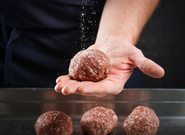 Chef making meat balls for smash burger in kitchen.