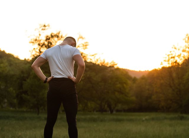 Post-Workout Recovery And Muscle Soreness Athlete Stretching Back After Exercise At Sunset In Nature Fitness And Wellness Physical Therapy And Injury Prevention.