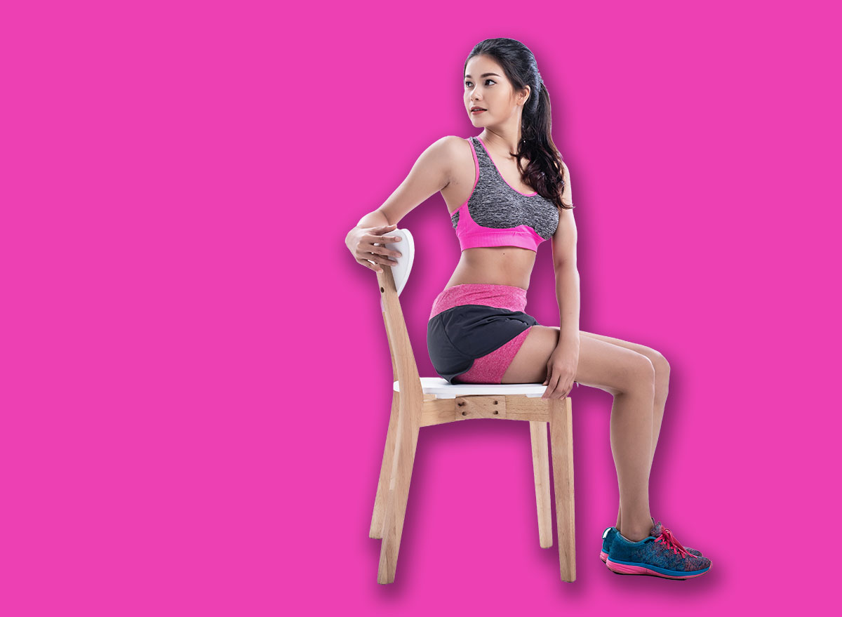 The beauty lady is wearing exercise suit,sitting on wooden chair,core tight and twisting trunk,keep head nice and long,basic pattern for exercise
