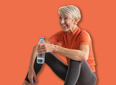 Beautiful senior woman drinking water after exercise. Active senior woman practicing yoga indoors. Exercise for Older Adults