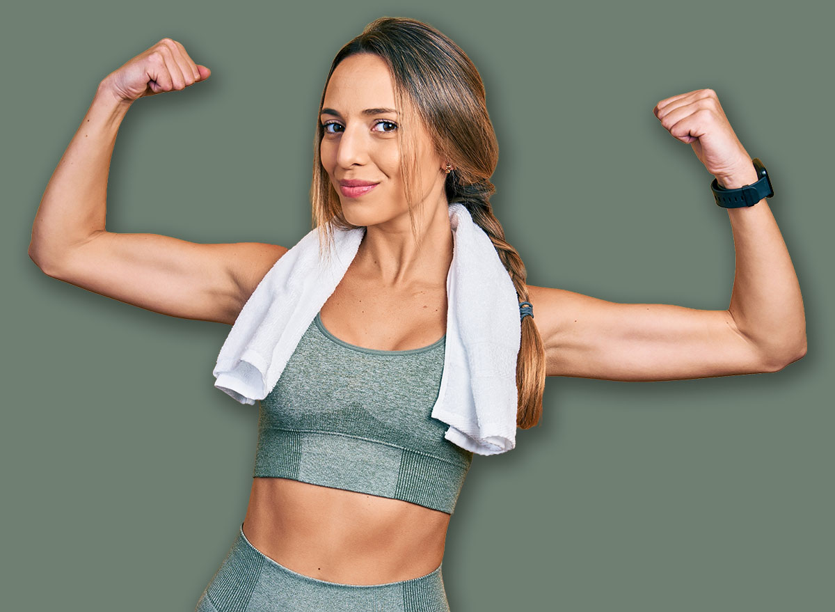 Beautiful hispanic woman wearing sportswear and towel showing arms muscles smiling proud. fitness concept.