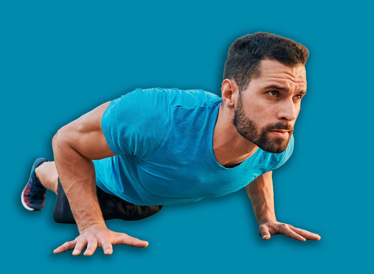 Athletic man doing pushup exercise in a city during street workout