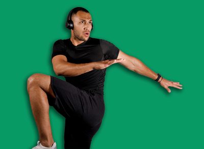 Sporty African American Man Doing Elbow To Knee Crunch Exercise And Listening To Music, Wearing Wireless Headphones On White Studio Background. Fitness Workout Playlist. Panorama, Copy Space