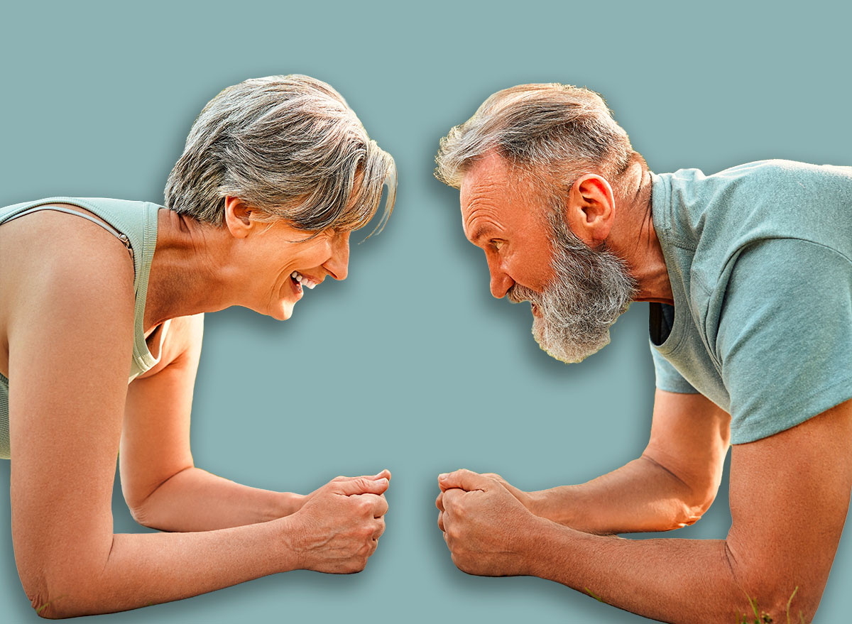 Endurance competition. Close up of two aged individuals standing head to head in plank position and gazing at each other. Motivated people working on strengthening muscles of abdomen and back.
