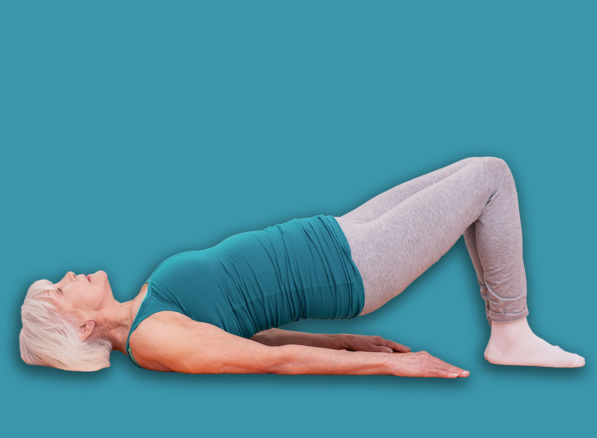 Stronger muscles. Charming elderly woman lying on the yoga mat and lifting her pelvic while doing morning exercises