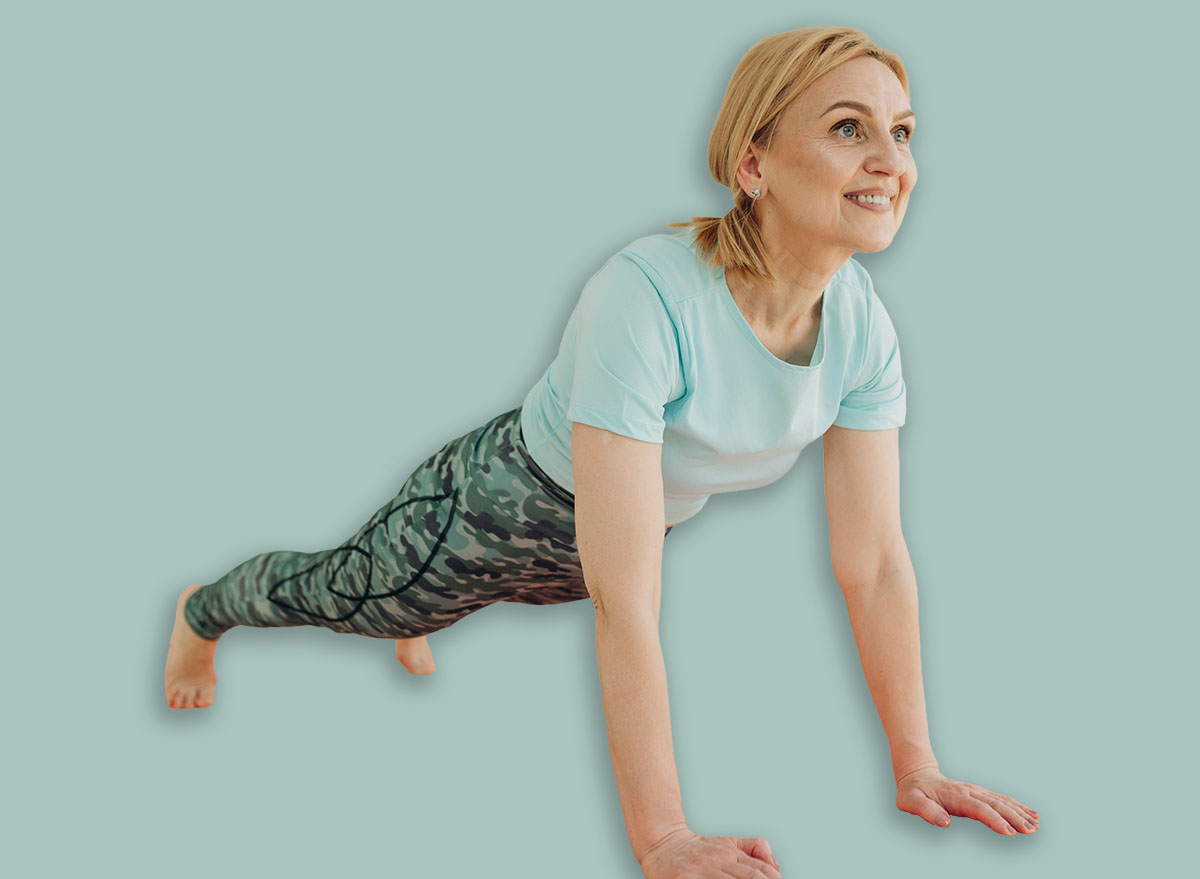 Attractive senior woman training at home. Mature woman standing in plank position. The concept of a healthy lifestyle and exercise at home