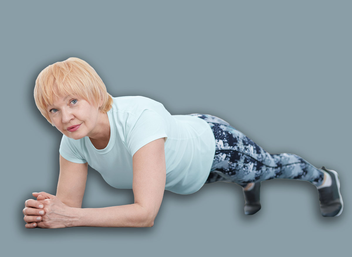 Senior woman in sportswear doing plank exercise at home