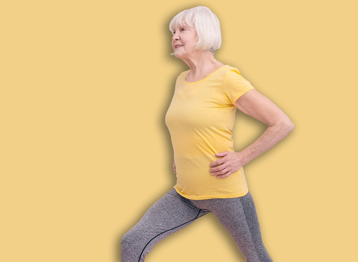 Dynamic exercises. Charming elderly lady doing lunges at home while carrying out morning calisthenics