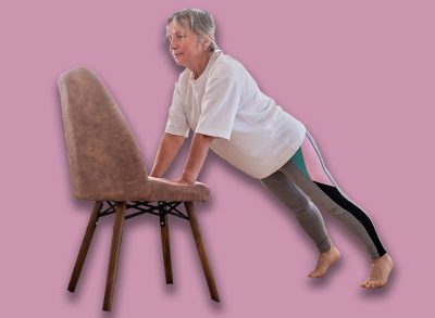 Senior caucasian woman doing yoga at home on chair